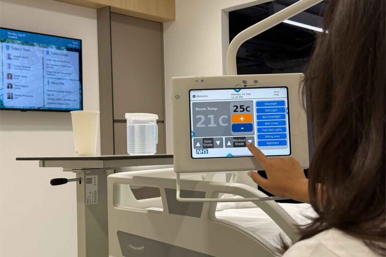 Patient using digital bedside screen in a future healthspaces NHS room with advanced hospital technology.